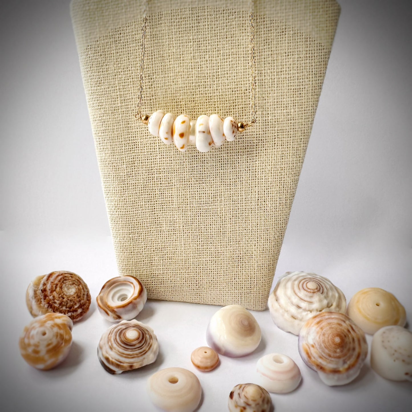 Small multiple Puka seashell floating necklace with white pearl
